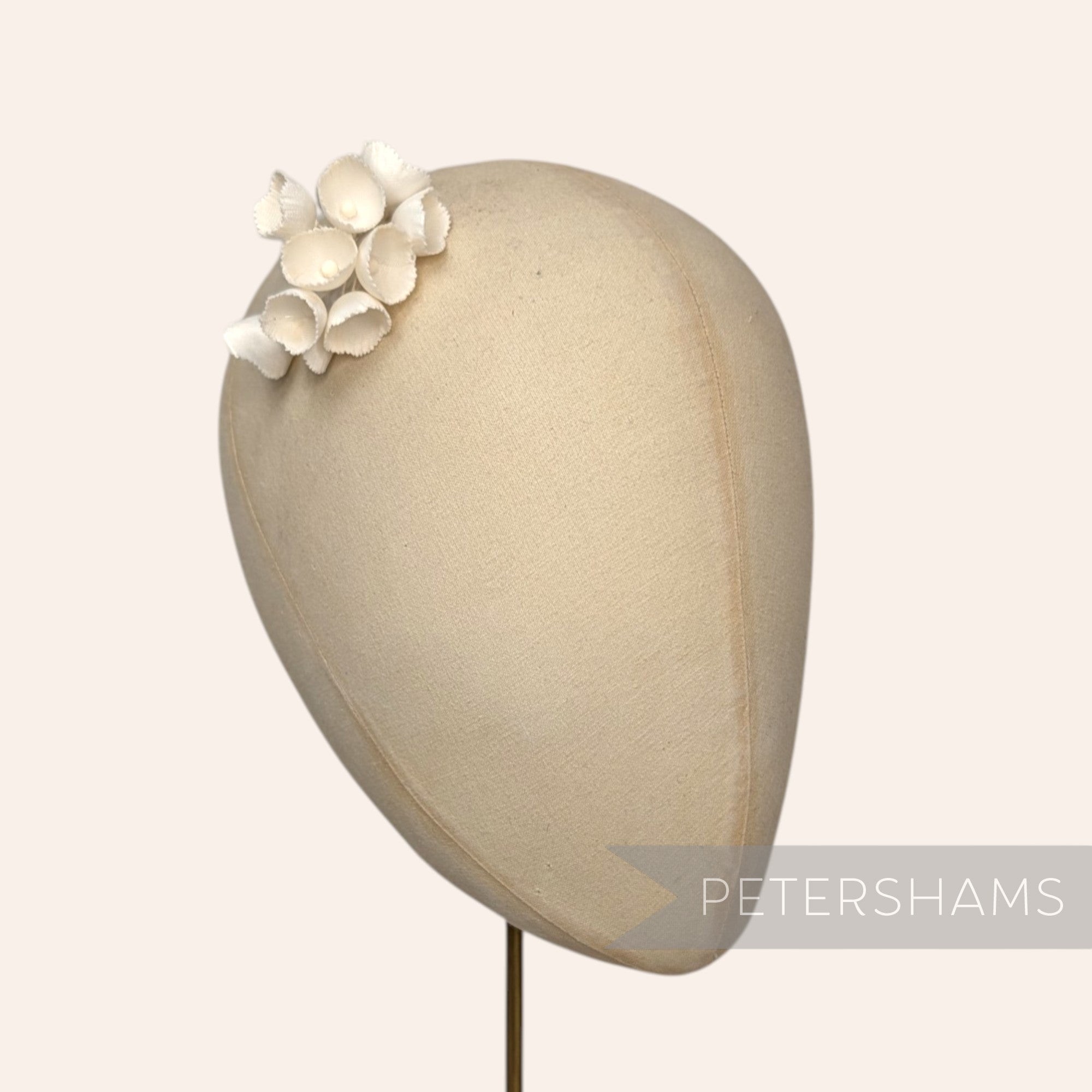 Petershams Millinery Supplies small white silk lily of the valley flower cups on a millinery head block
