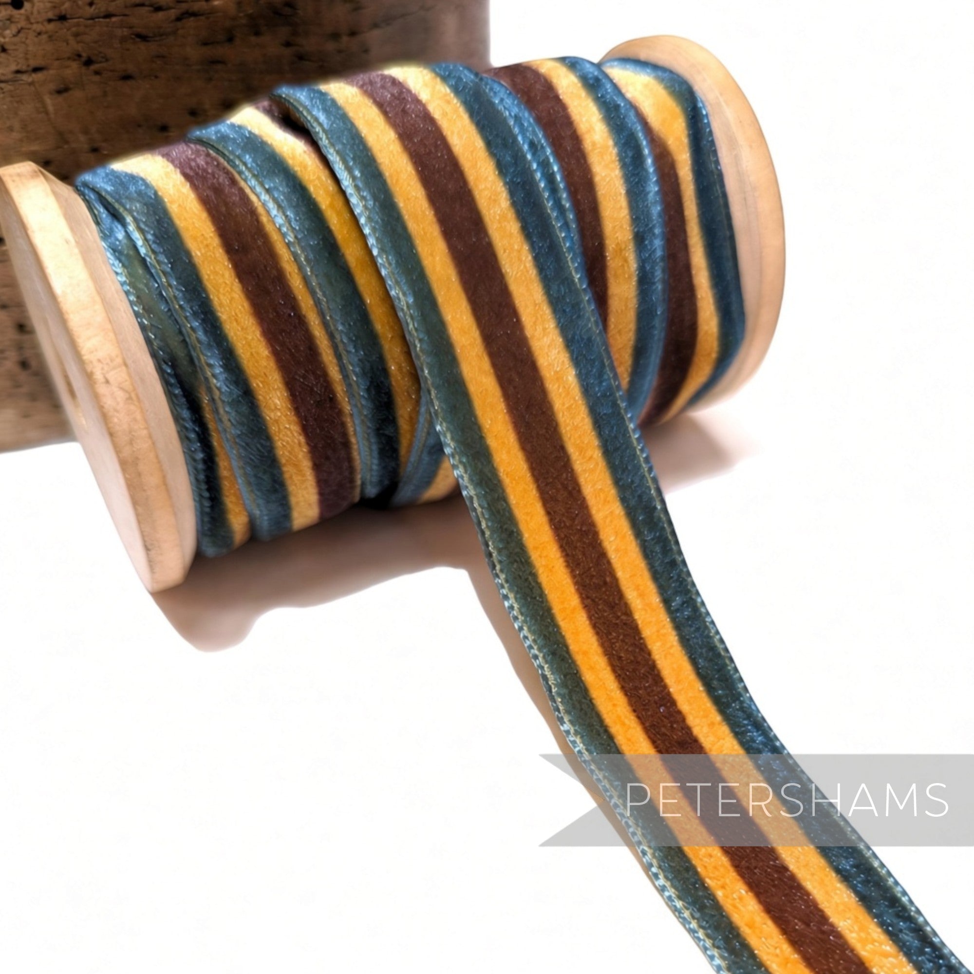 Petershams Millinery Supplies 23mm striped French velvet ribbon in blue, brown, and gold on a wooden spool