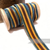 Petershams Millinery Supplies 23mm striped French velvet ribbon in blue, brown, and gold on a wooden spool