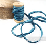 Petershams Millinery Supplies 5mm teal velvet insertion piping cord on a wooden spool for millinery and sewing.