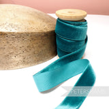 Petershams Millinery Supplies 24mm teal vintage rayon velvet ribbon on a wooden spool next to a wooden hat block