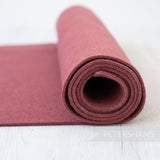 Petershams Millinery Supplies 3mm thick thermoformable wool felt fabric in a dusty rose colour rolled on a white surface