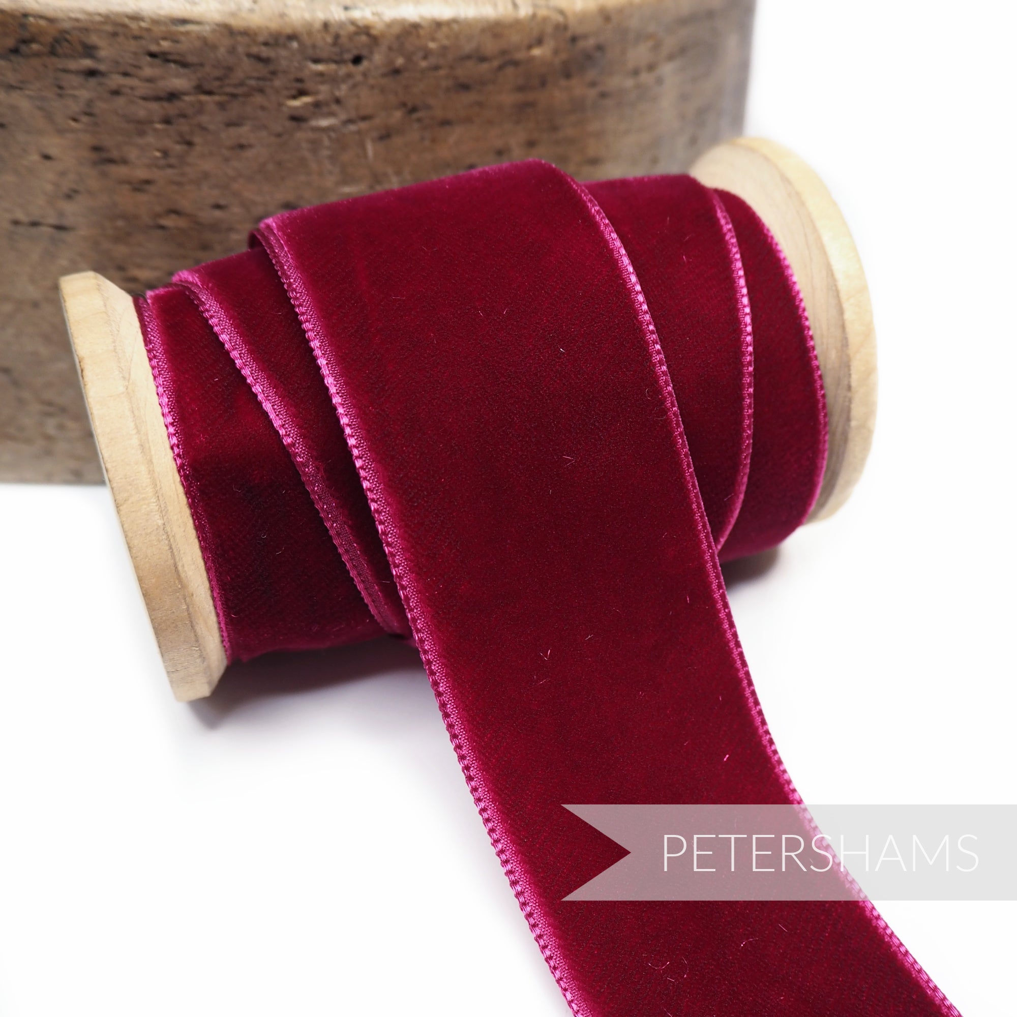 Petershams Millinery Supplies 36mm berry French velvet ribbon on a wooden spool with a luxurious sheen.