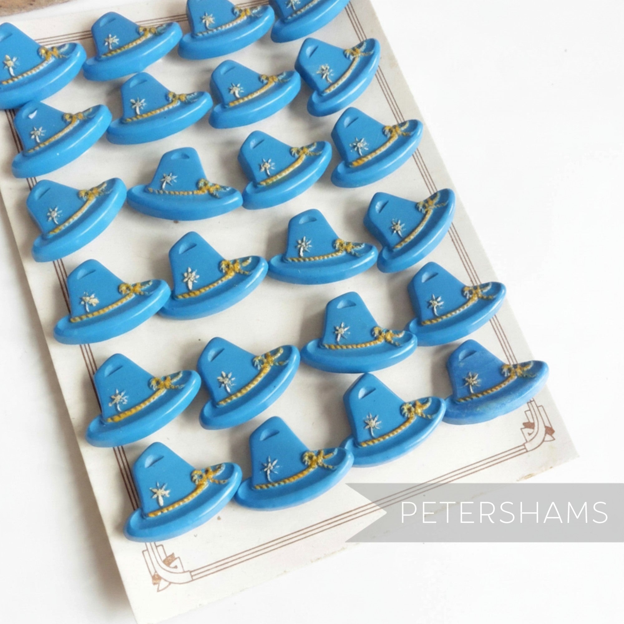 Petershams Millinery Supplies vintage 1940s blue Alpine hat buttons with raised rope and flower relief detail