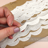 Petershams Millinery Supplies vintage off-white Austrian triple scallop lace trim on a cardboard spool