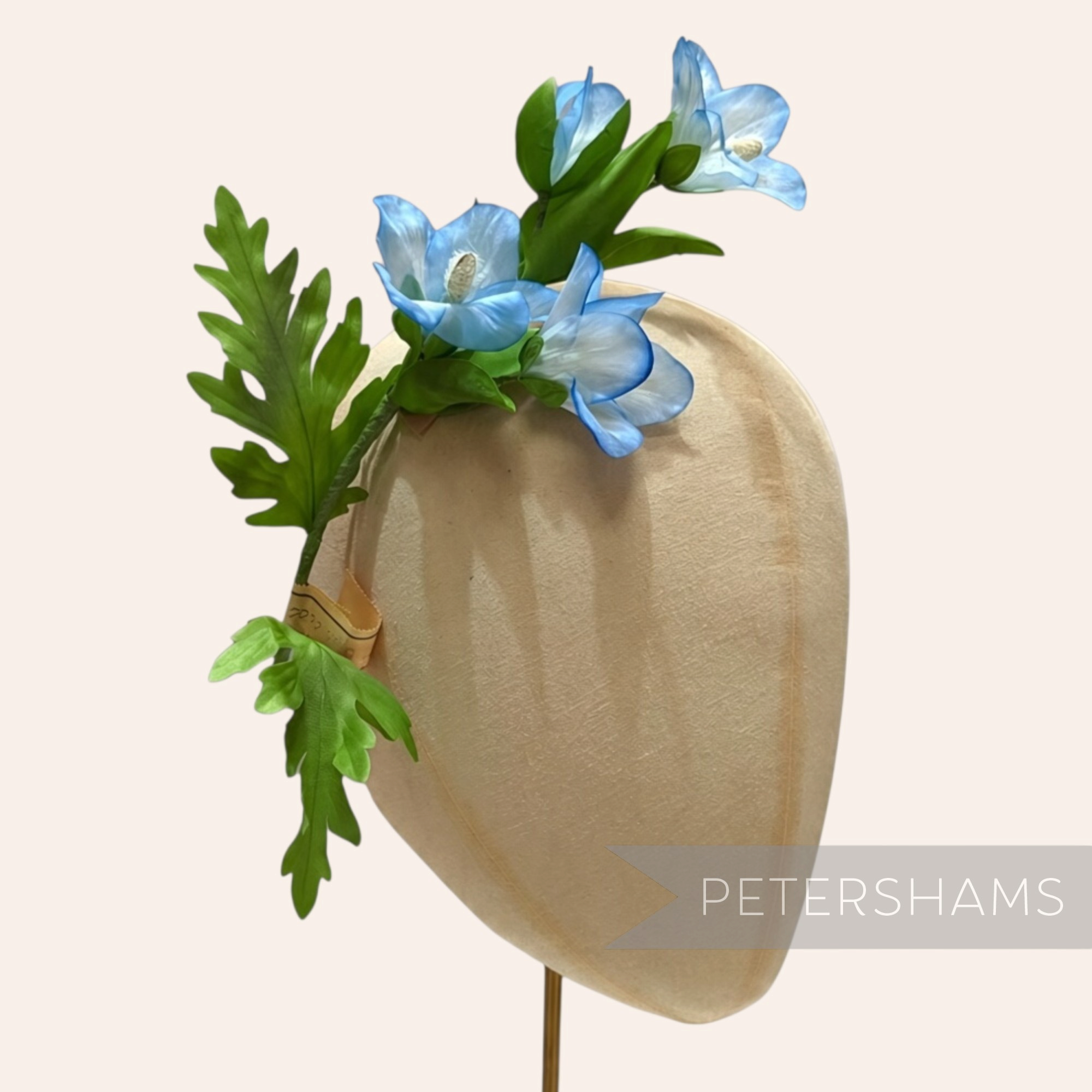 Petershams Millinery Supplies vintage Petra blue trumpet flower branch with green leaves on a millinery head block