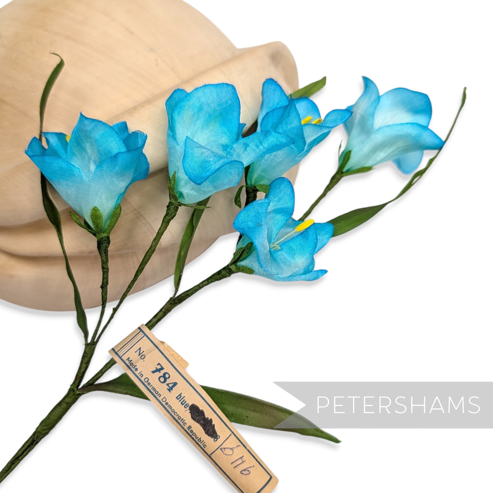 Petershams Millinery Supplies vintage 1960s blue silk freesia flower mount with wired stems and green leaves.