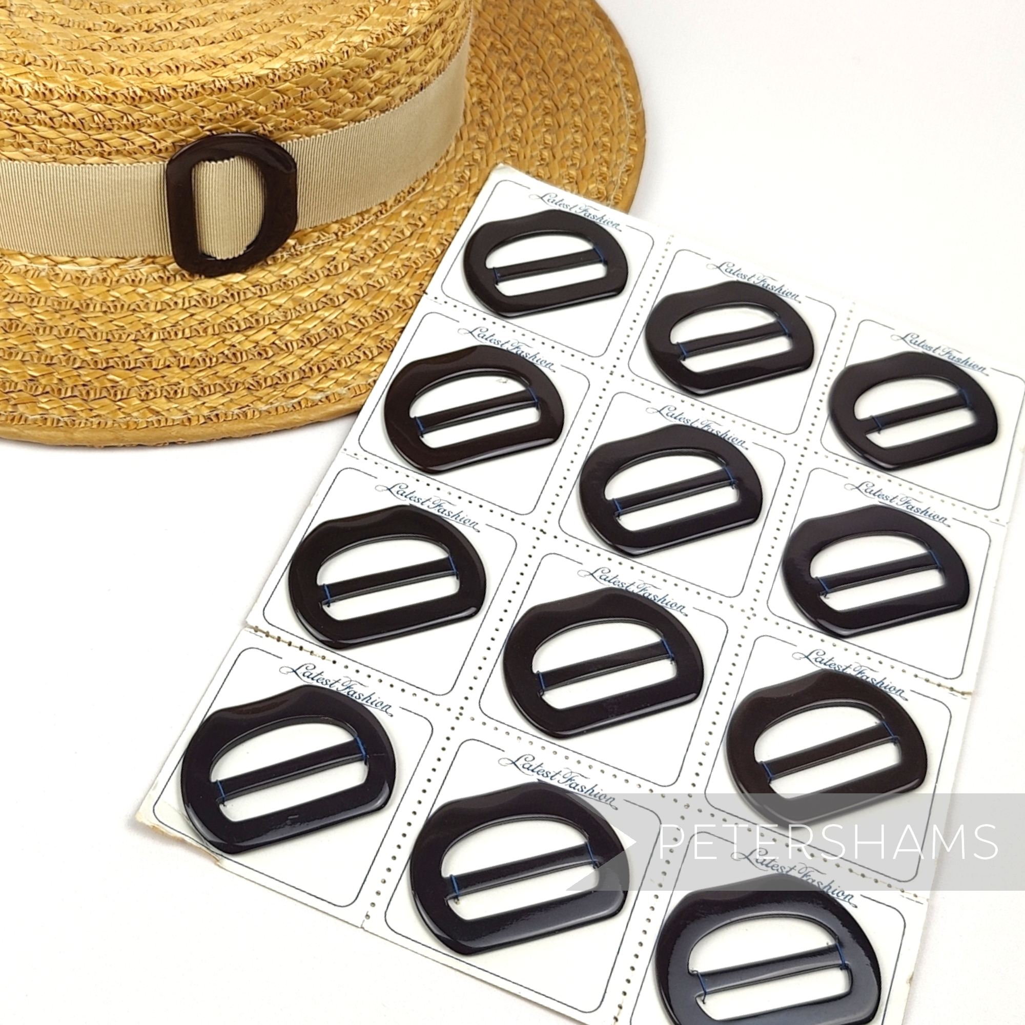 Petershams Millinery Supplies vintage 1950s chocolate brown D-shape plastic buckle on a straw hat and display card.