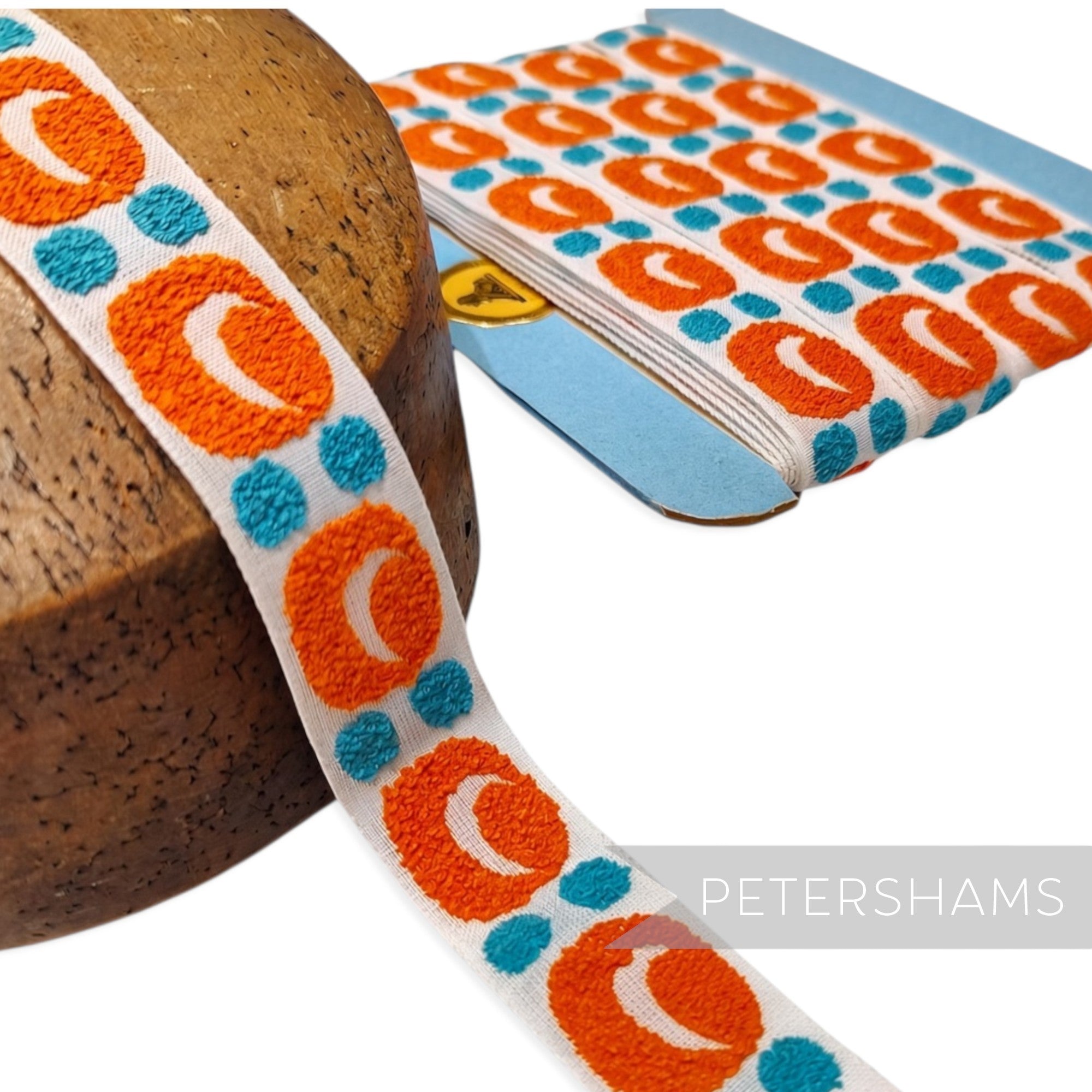 Petershams Millinery Supplies vintage 26mm woven cotton ribbon with orange and blue bubbly pattern on white background