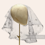 Petershams Millinery Supplies vintage 1930s honeycomb veiling round with black X-shaped embroidery on a hat block