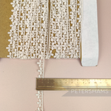 Petershams Millinery Supplies vintage 1950s ivory cotton guipure lace trim with star and fleur design on a card