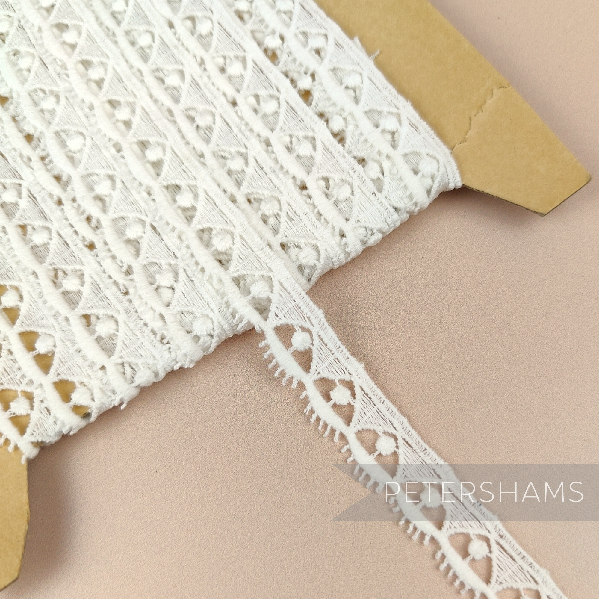 Petershams Millinery Supplies vintage off-white guipure lace trim with a 15mm lashy triangle dot pattern on a spool.