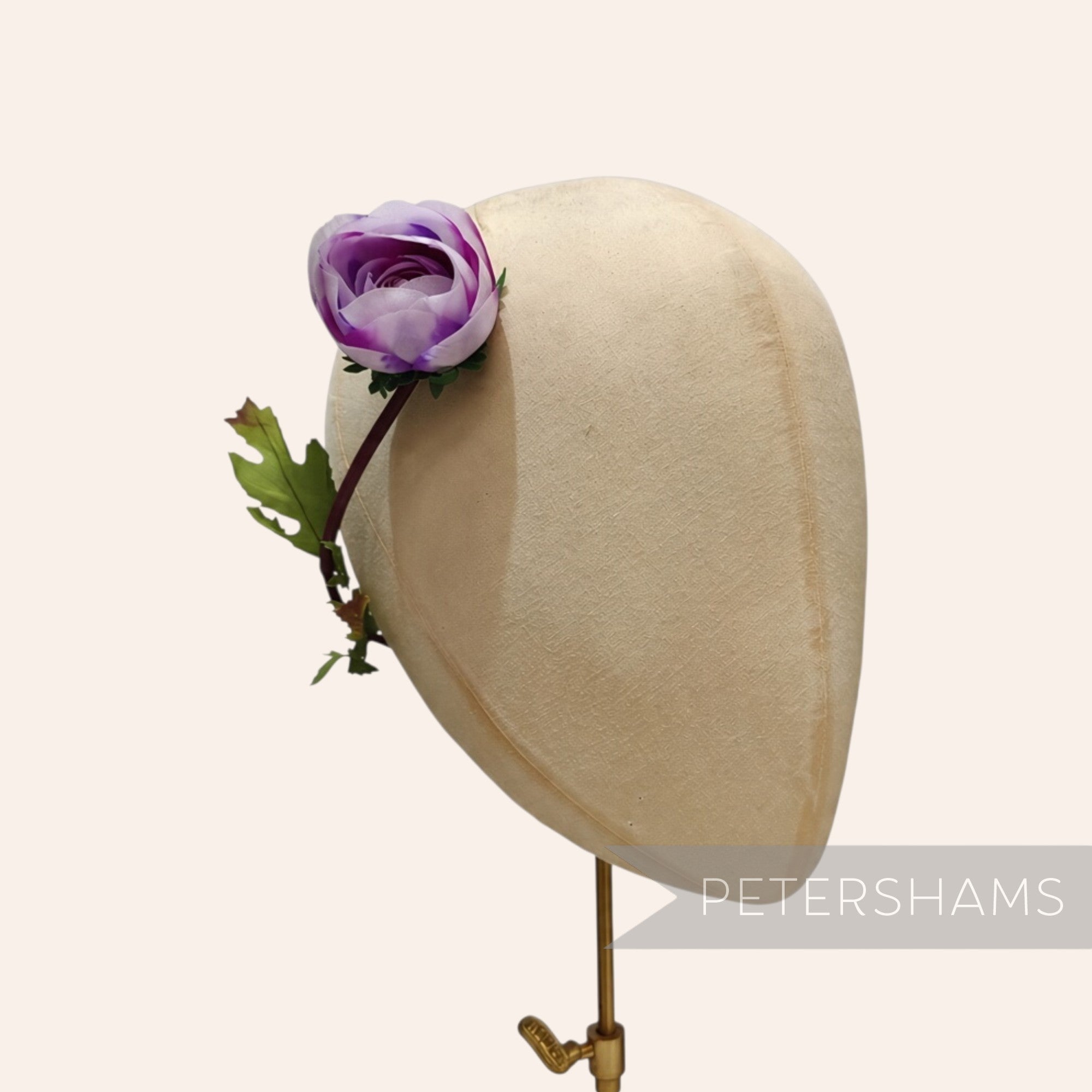 Petershams Millinery Supplies vintage purple silk rosebud with wired leaves on a millinery head block