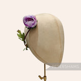 Petershams Millinery Supplies vintage purple silk rosebud with wired leaves on a millinery head block