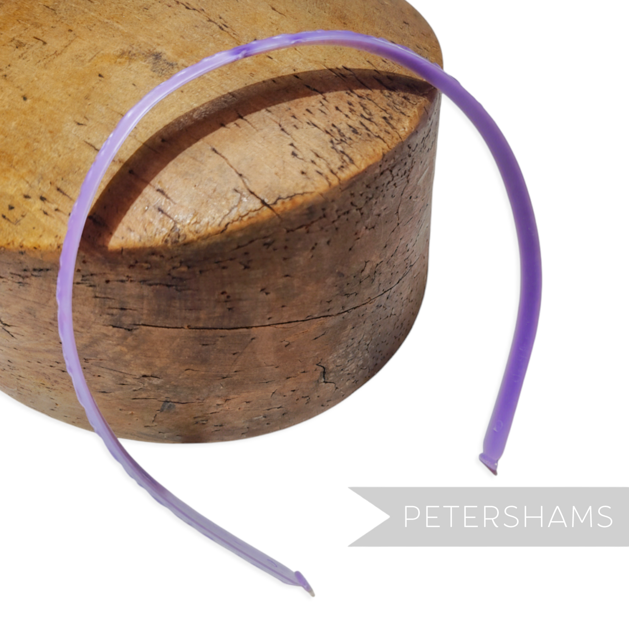 Petershams Millinery Supplies vintage 1960s skinny purple plastic headband with swirl pattern and glossy finish.