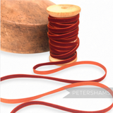 Petershams Millinery Supplies 7mm vintage rust red velvet ribbon on a wooden spool next to a millinery block