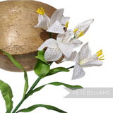 Petershams Millinery Supplies vintage silk lily flower spray with white petals, yellow stamens, and green leaves.