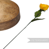 Petershams Millinery Supplies vintage yellow silk rosebud with wired leaves and stem next to a wooden millinery block.