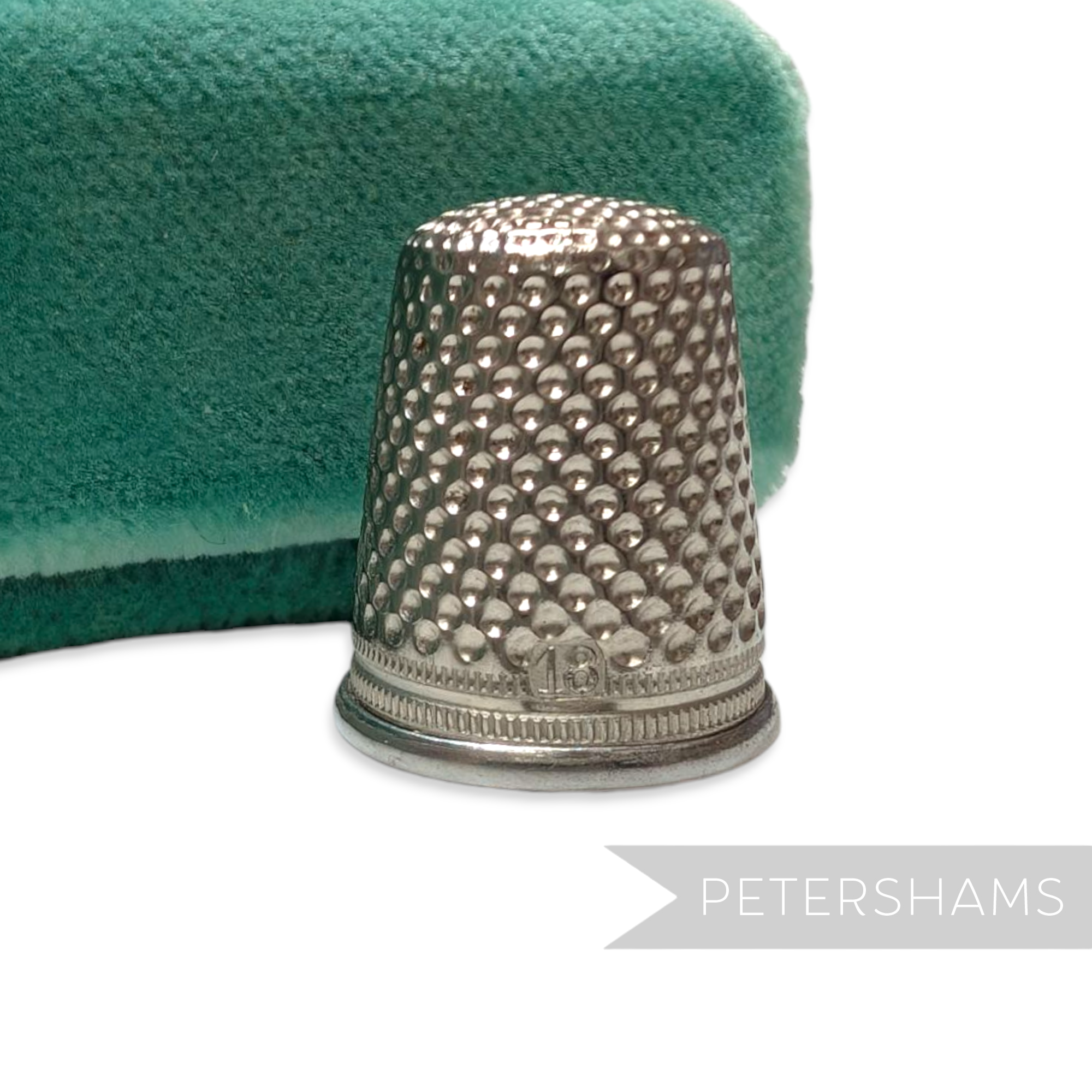 Petershams Millinery Supplies vintage German steel sewing thimble with dimpled texture on a green velvet background