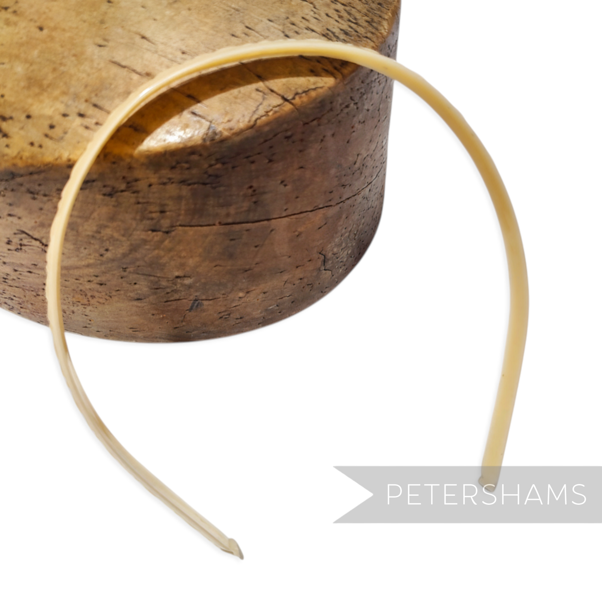 Petershams Millinery Supplies vintage 1960s skinny headband with a glossy finish and swirl pattern in a pale cream colour.