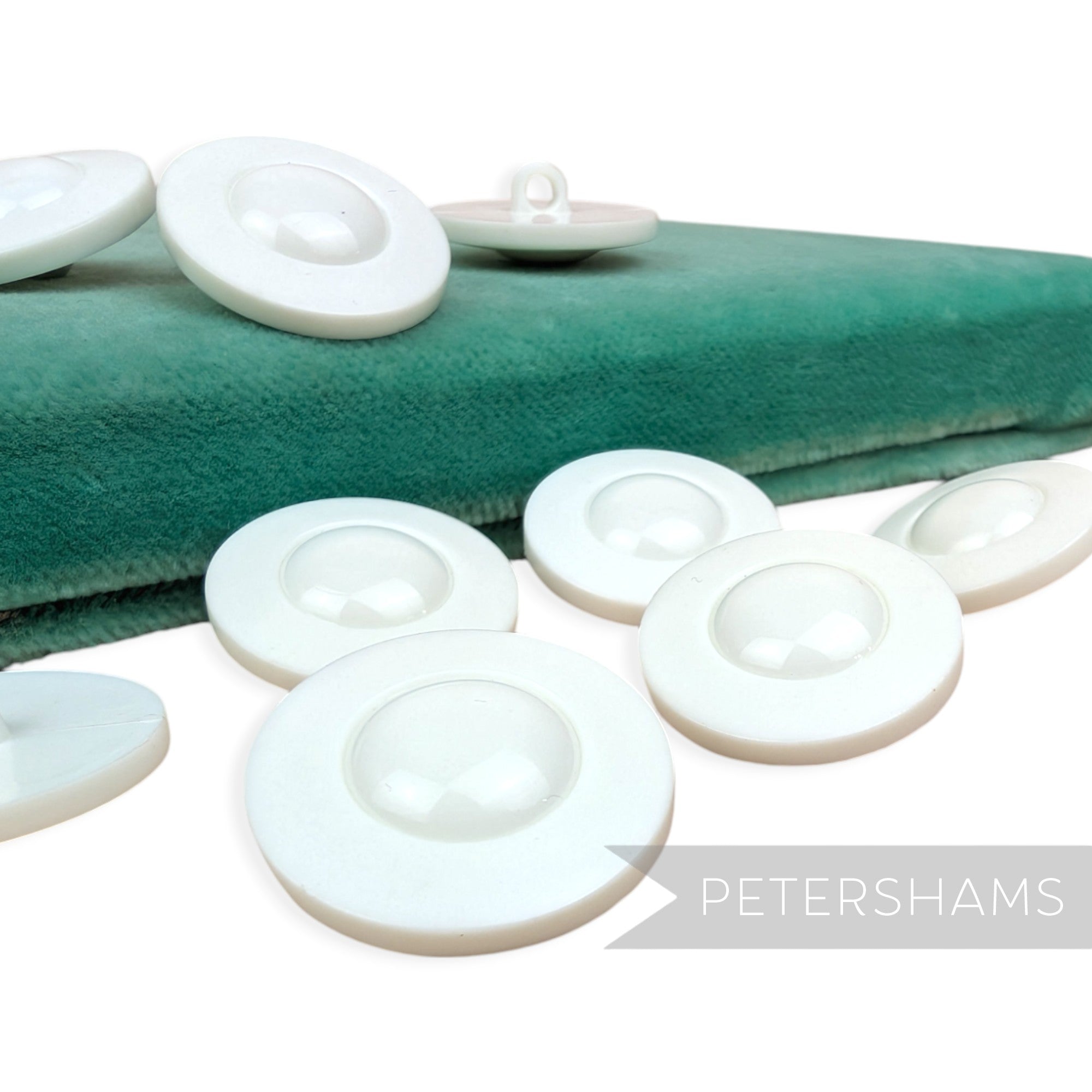 Petershams Millinery Supplies vintage 1960s UFO style white plastic shank buttons with a shiny dome and satin rim.