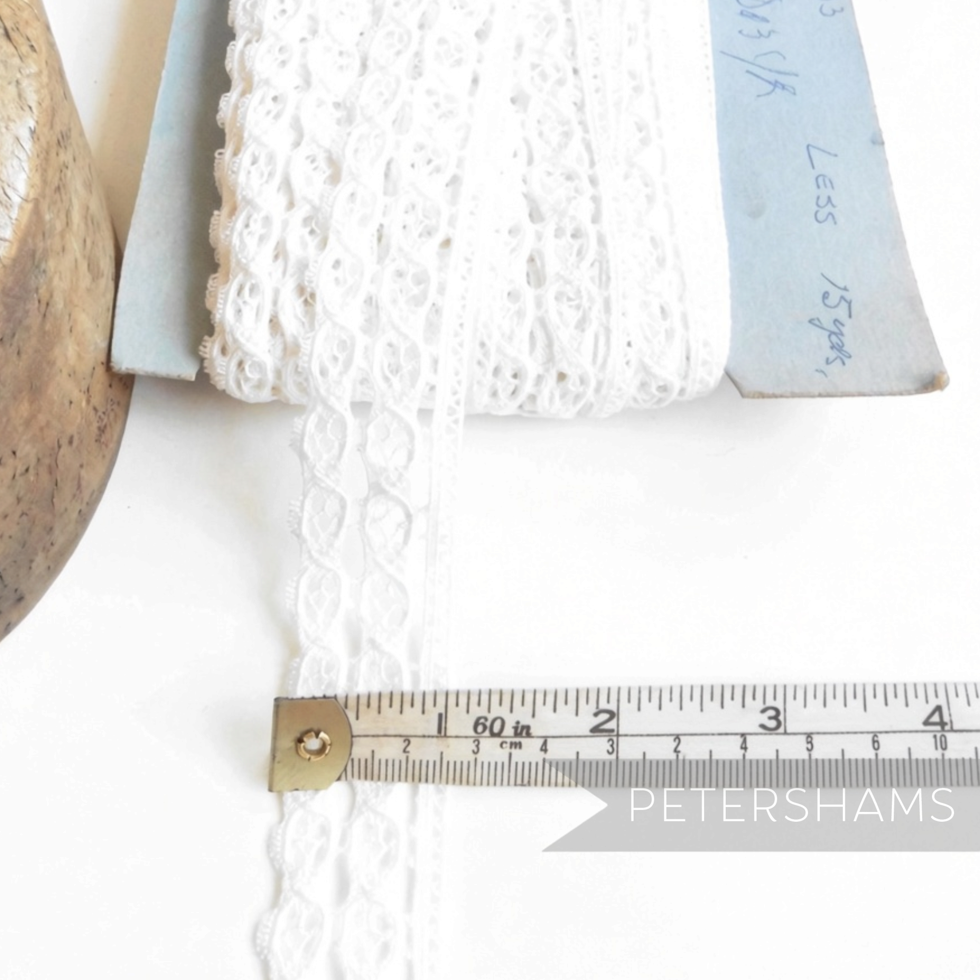 Petershams Millinery Supplies 25mm vintage white double row fine lace trim on a spool with a measuring tape.