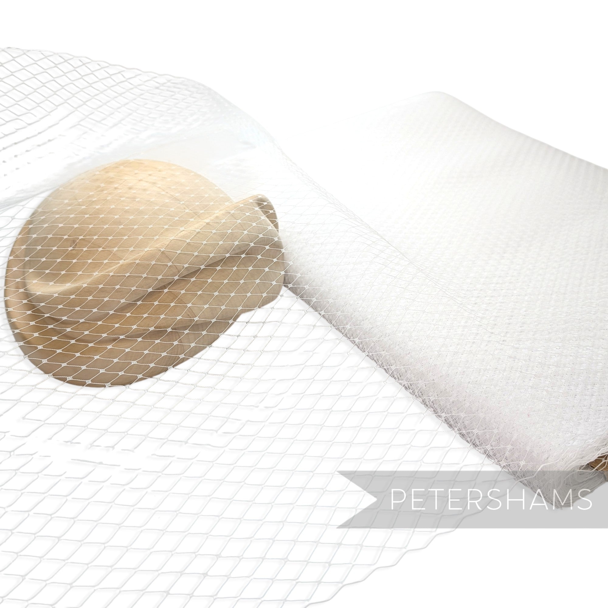 Petershams Millinery Supplies 18 inch wide white diamond pattern birdcage veiling draped over a beige hat base