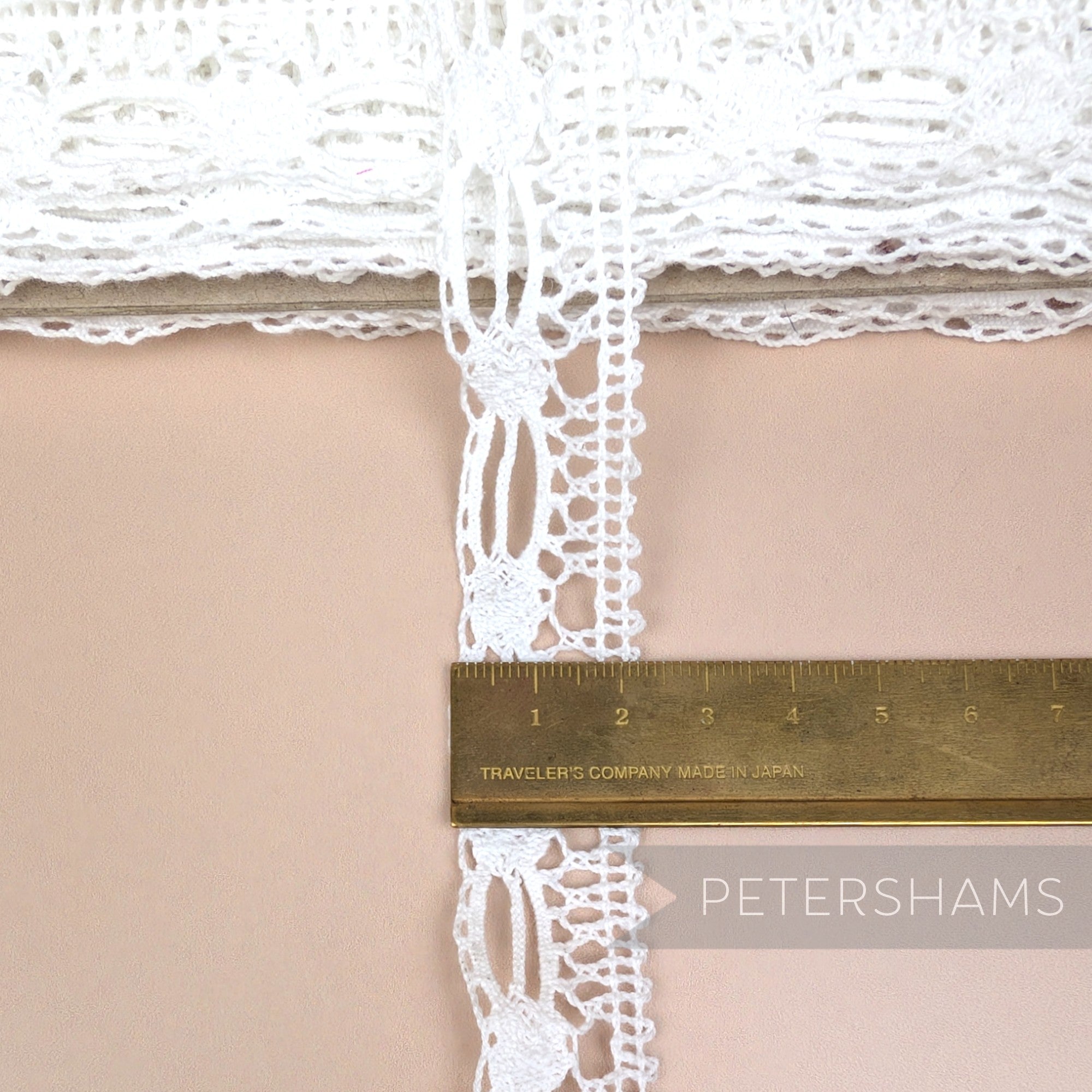 Petershams Millinery Supplies white 22mm cotton lace trim with an intricate dash and dot pattern on a spool