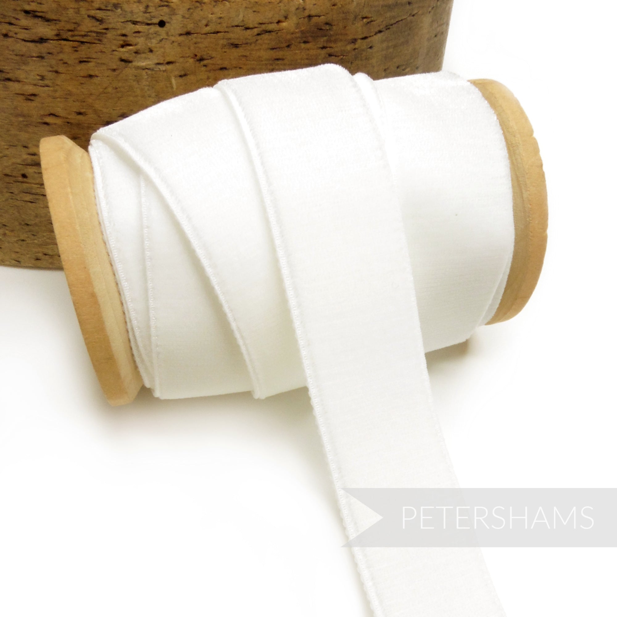 Petershams Millinery Supplies 23mm white elastic stretch velvet ribbon on a wooden spool for millinery projects