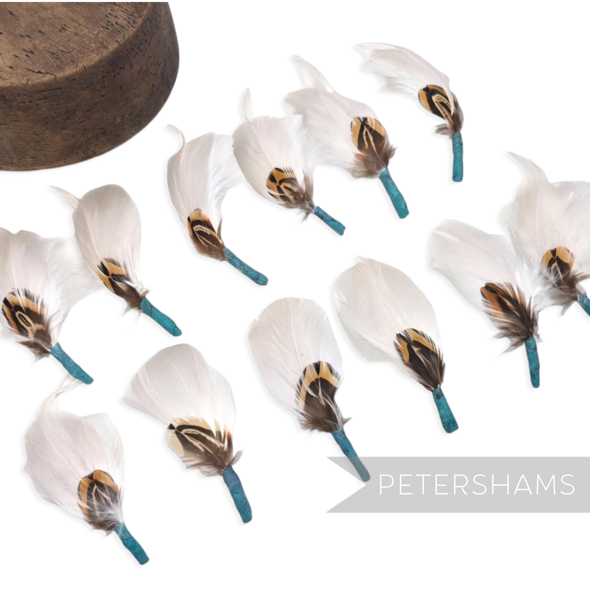 Petershams Millinery Supplies small white feather hat mounts featuring layered pheasant, hackle, and goose feathers.
