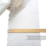 Petershams Millinery Supplies white sheer lace trim with a floral scale pattern and scalloped edges measuring 25cm wide
