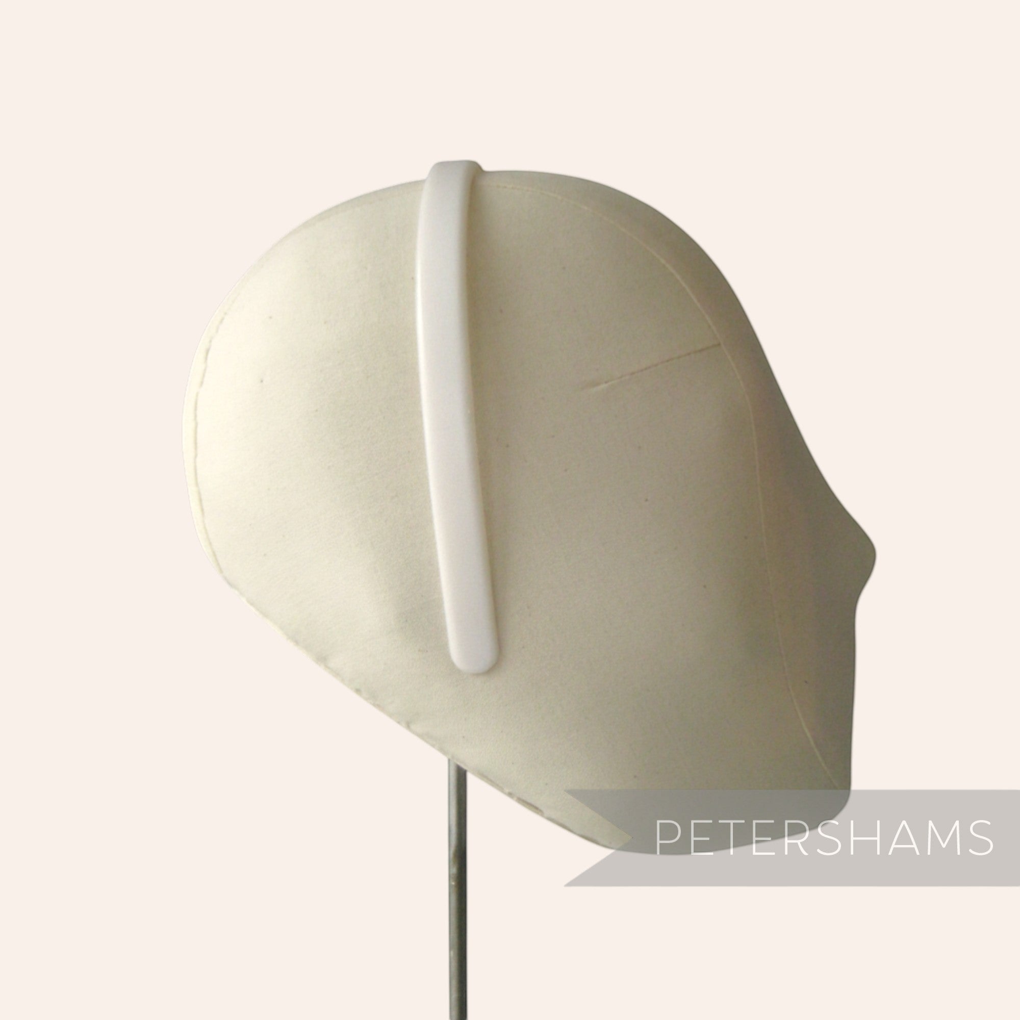 Petershams Millinery Supplies white plastic headband core blank on a mannequin head for DIY crafting and decoration.