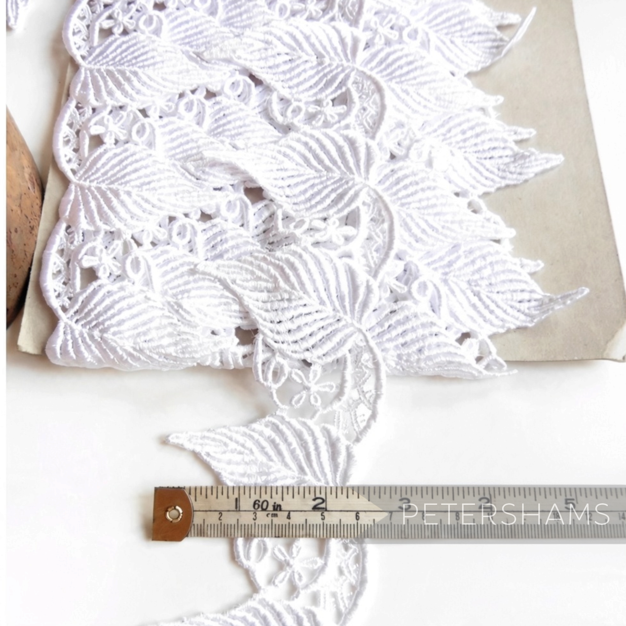 Petershams Millinery Supplies 6cm wide white guipure lace trim featuring a detailed flowing leaf design for bridal wear