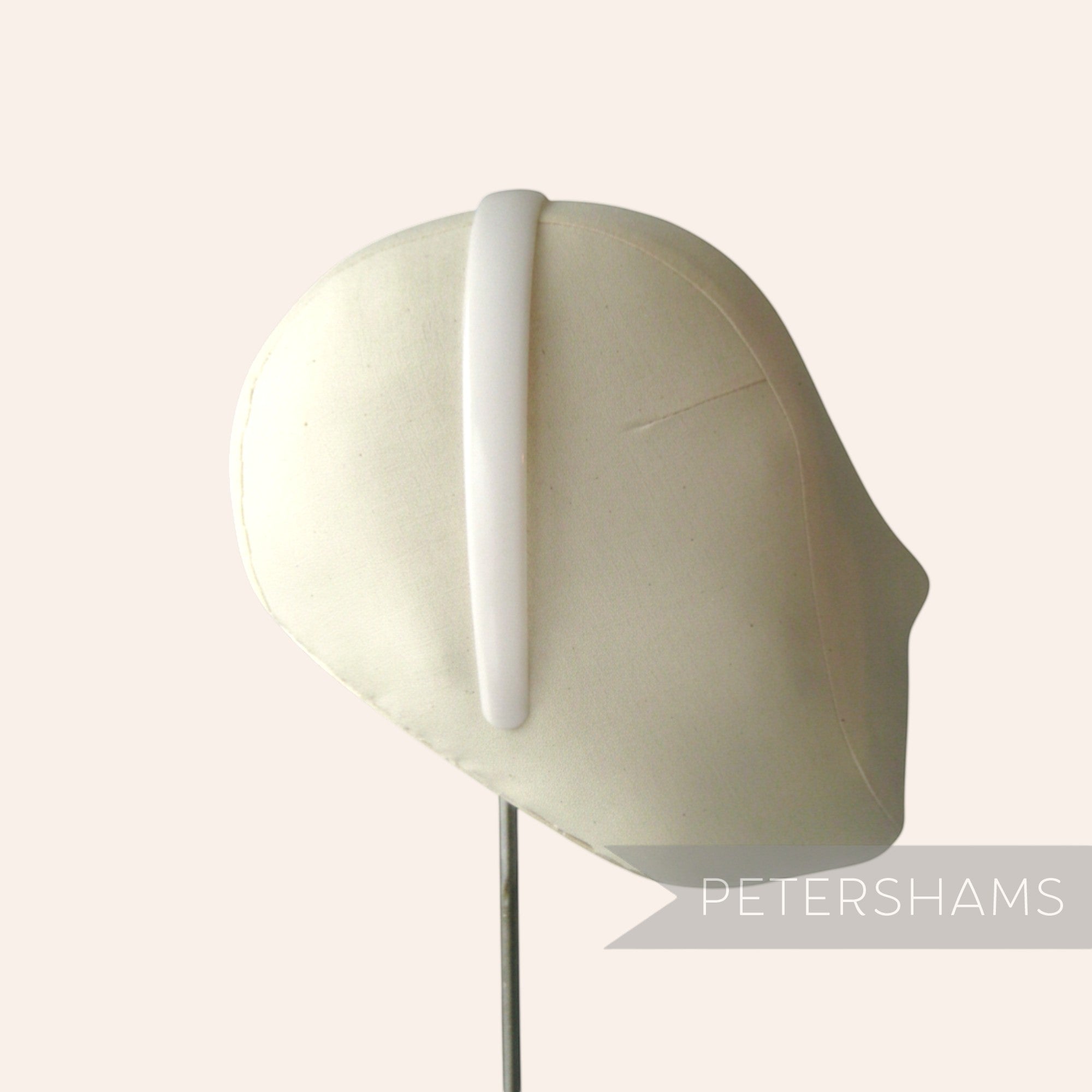 Petershams Millinery Supplies white plastic headband core blank on a fabric mannequin head for DIY craft projects