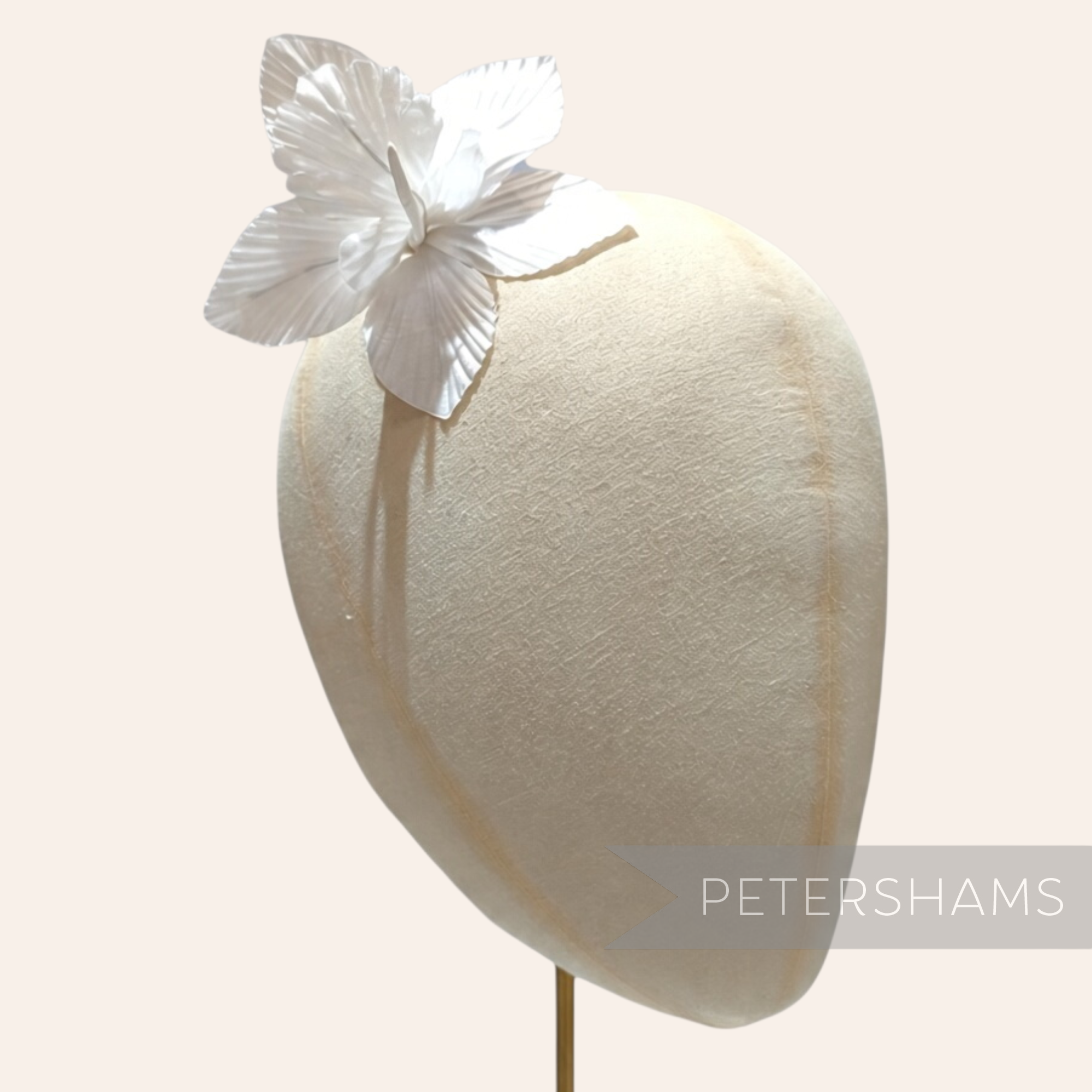 Petershams Millinery Supplies white silk orchid flower hat mount on a millinery head block