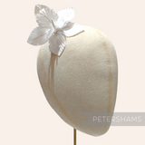 Petershams Millinery Supplies white silk orchid flower hat mount on a millinery head block