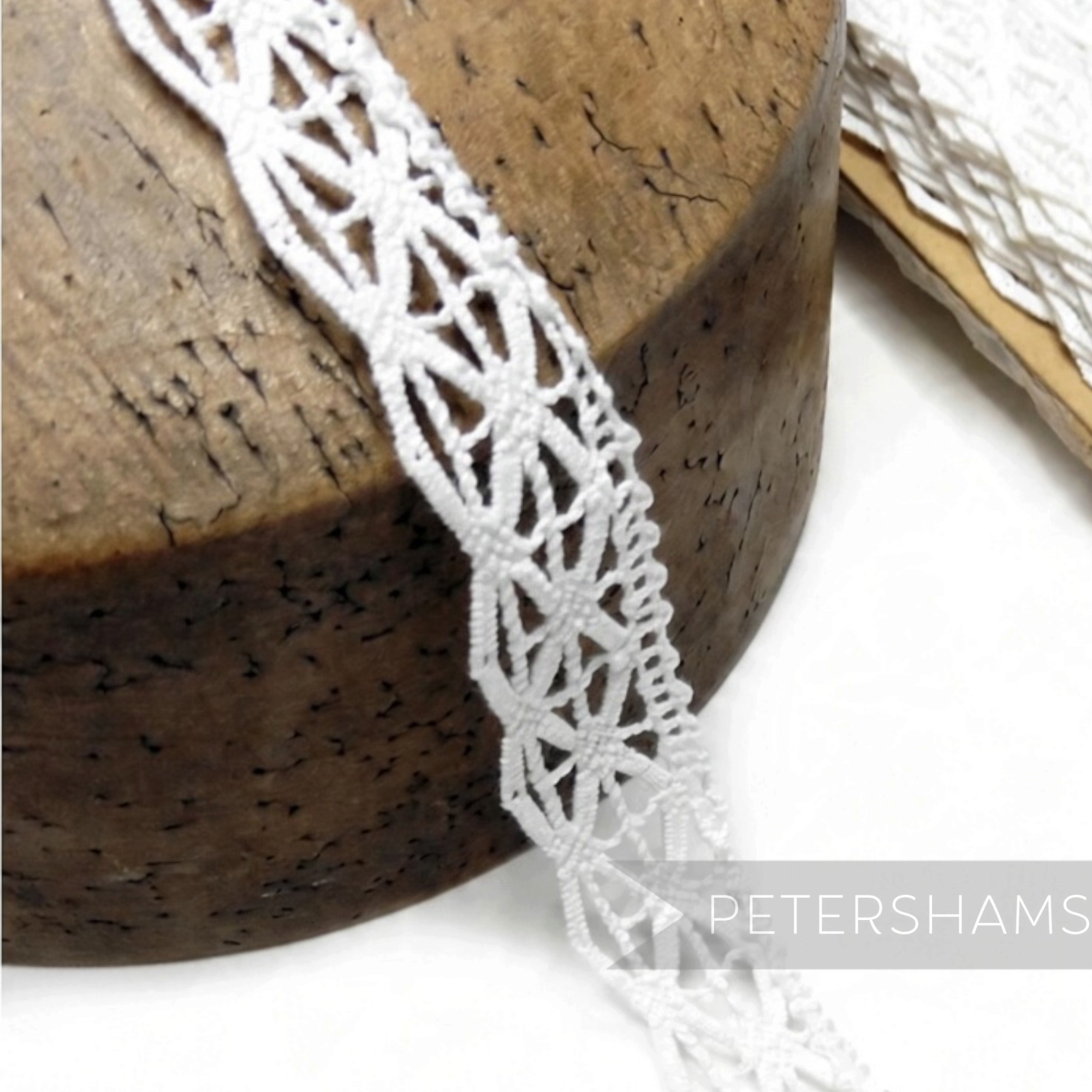 Petershams Millinery Supplies white cotton lace trim with a geometric triangle pattern for bridal and bonnet designs.