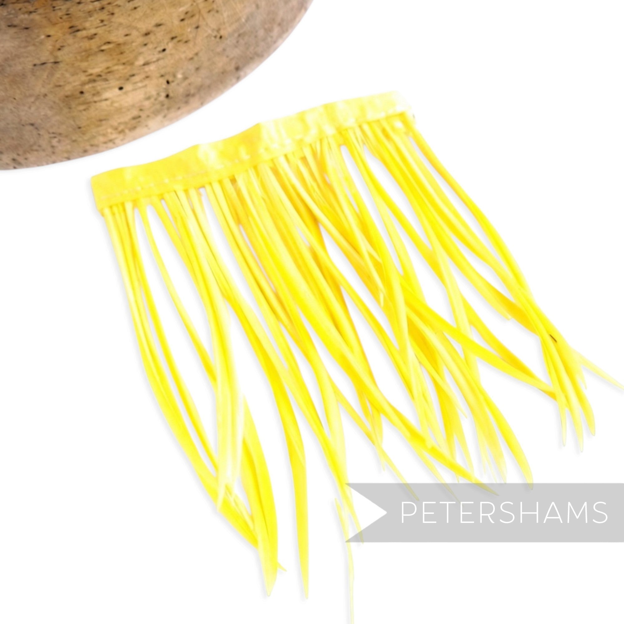 Petershams Millinery Supplies yellow goose biot feather fringe attached to a satin ribbon binding for millinery crafts.