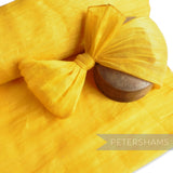 Petershams Millinery Supplies bright yellow polyester abaca fabric with a slightly glossy, rustic texture. Ideal for bows and loops.
