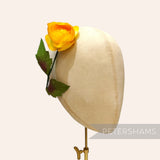 Petershams Millinery Supplies vintage yellow silk rosebud with green wired leaves on a millinery display head