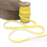 Petershams Millinery Supplies 10mm vintage yellow rayon velvet ribbon on a wooden spool next to a wooden hat block.