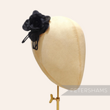 Petershams Millinery Supplies Zahra black silk flower hat mount with wired leaves on a millinery head block