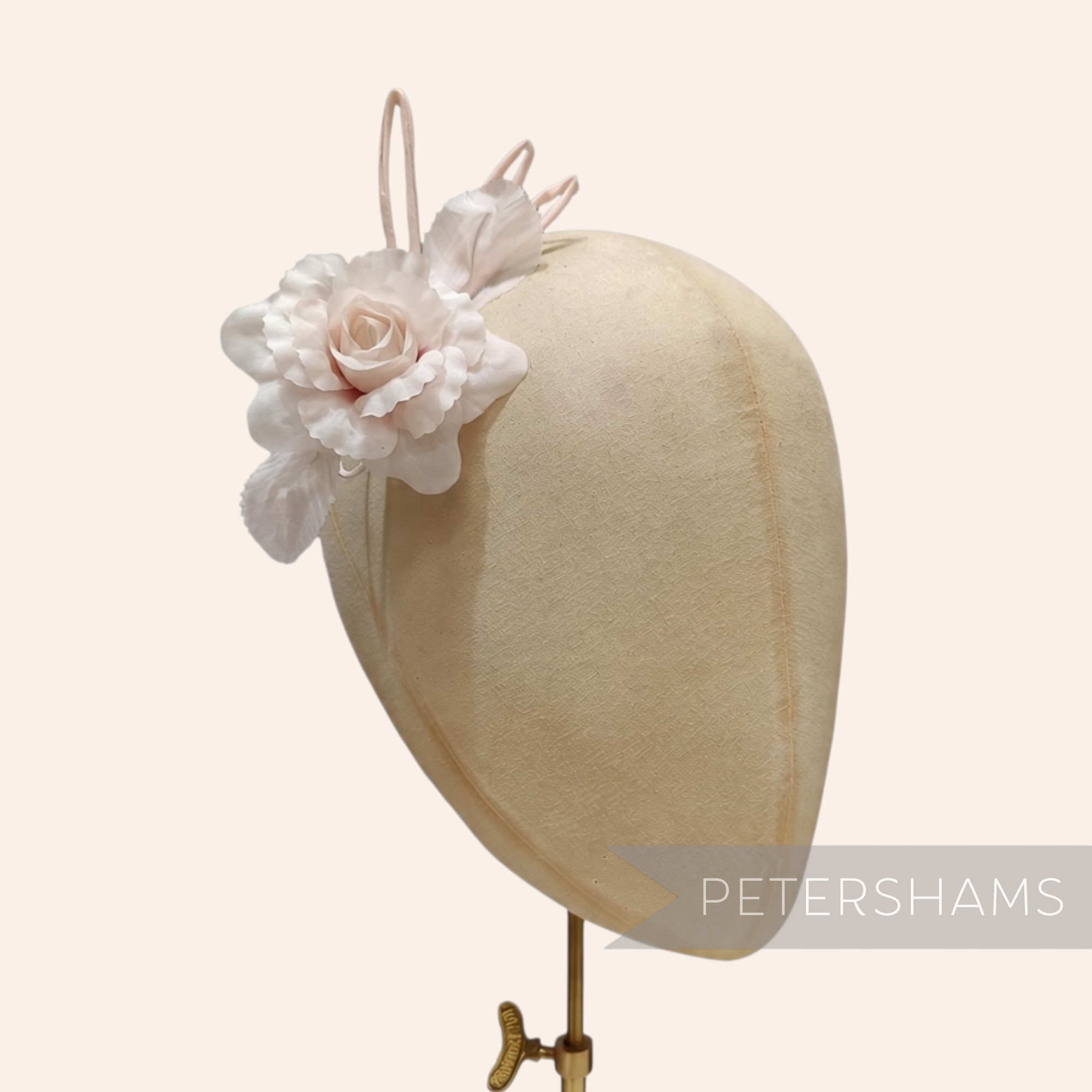 Petershams Millinery Supplies Zahra petite pale pink silk flower hat mount with wired leaves on a millinery head block.