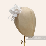 Petershams Millinery Supplies Zahra white silk flower hat mount with wired leaves on a millinery head block