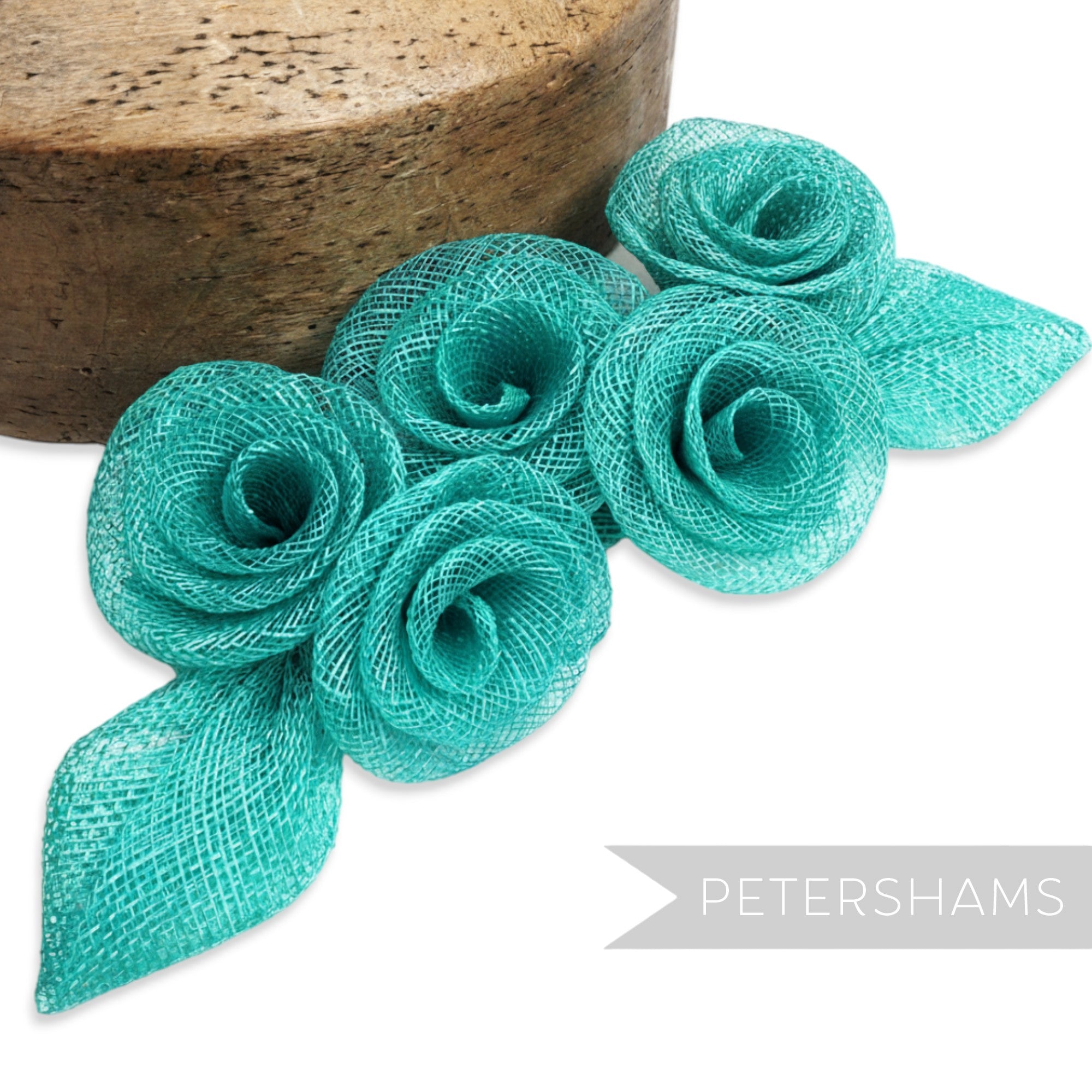 Petershams Millinery Supplies teal sinamay abaca flower and leaf hat mount. Five roses with two leaves.