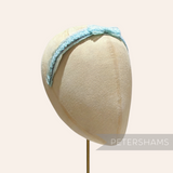 Petershams light blue vintage 1960s laminated raffia and crin braid headband with a small bow.
