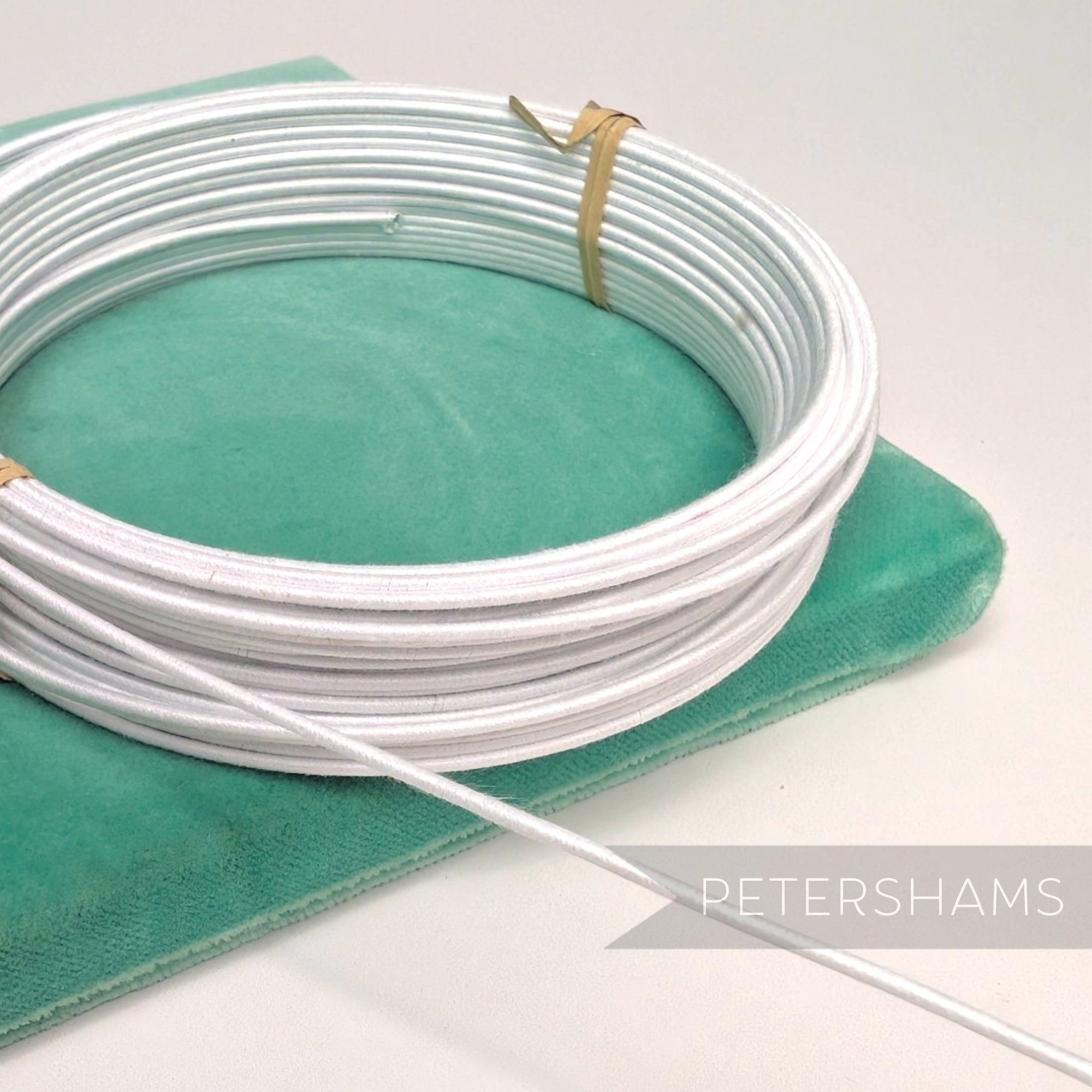 Petershams white 1.4mm cotton-covered millinery wire for hat bases and forms.