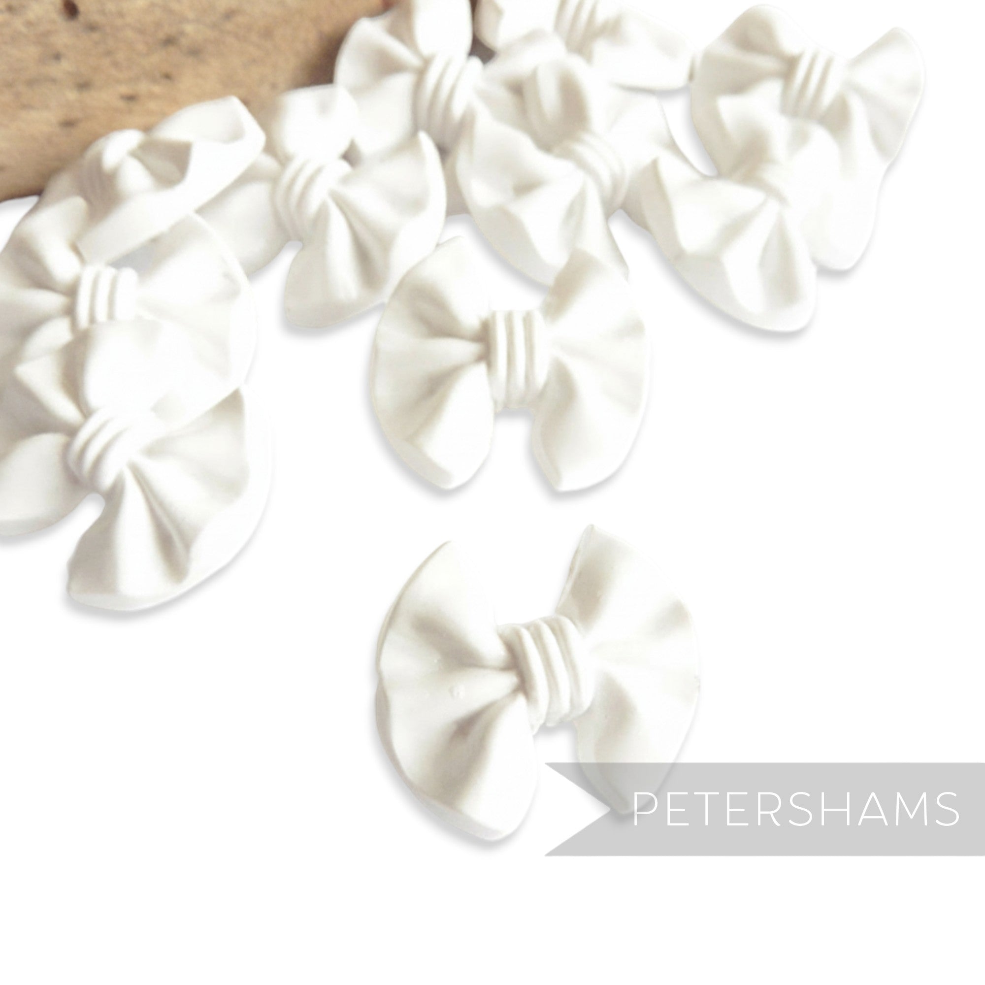 Petershams Millinery Supplies white plastic vintage bow buttons with central back shank. 20mm x 17mm.