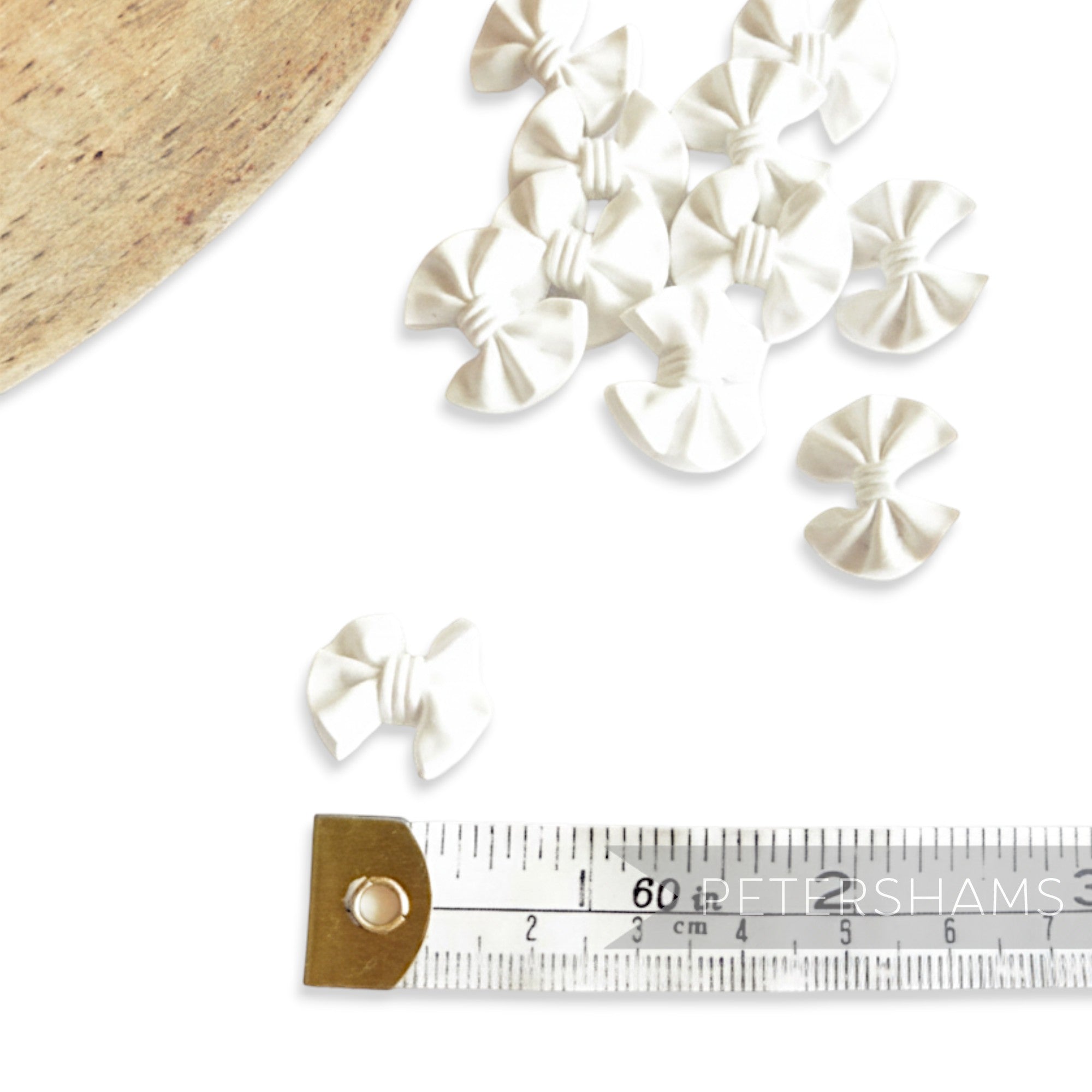 Petershams white plastic vintage bow buttons with central back shank, 20mm x 17mm.