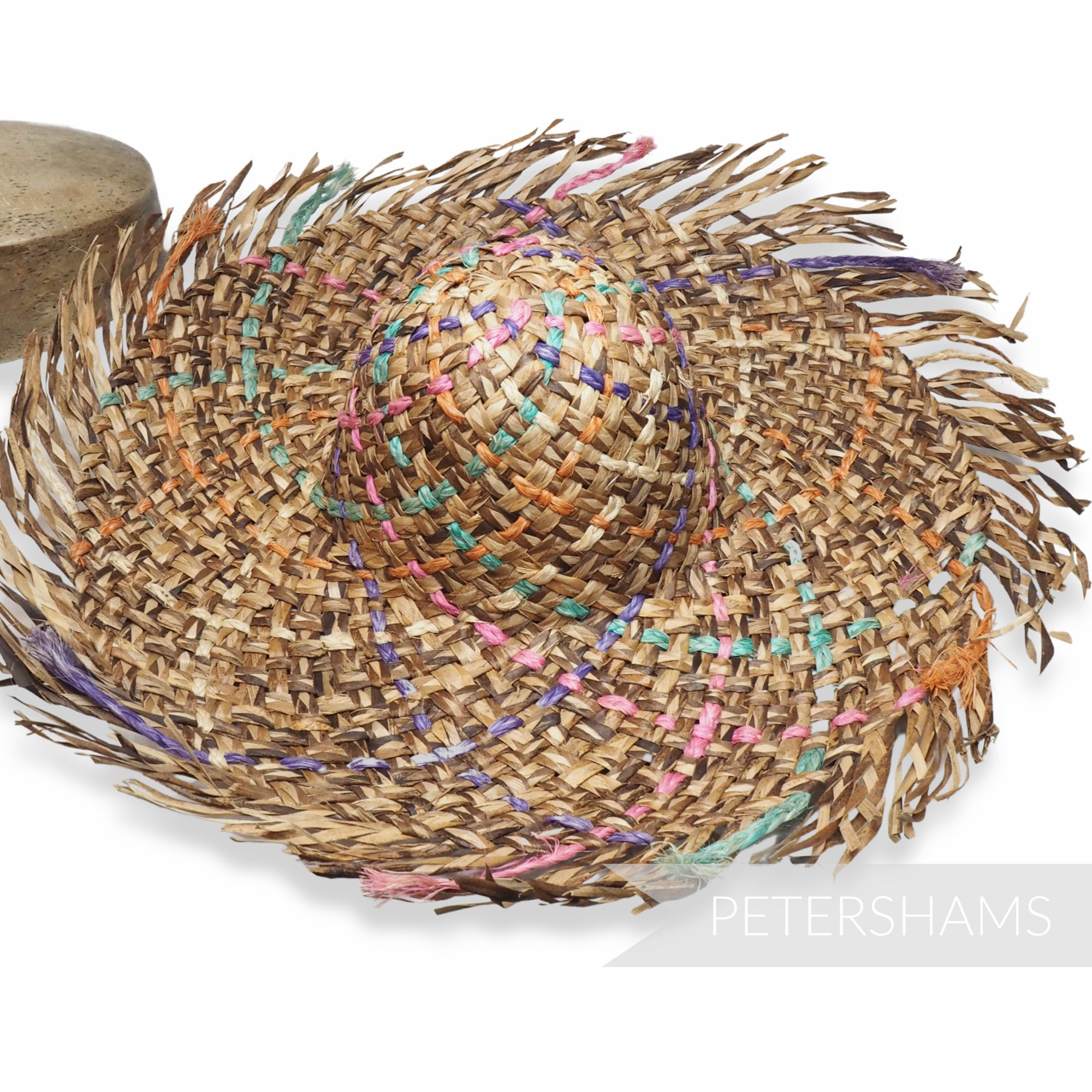 Petershams Millinery Supplies dark straw capeline with a fringed brim and colorful woven rope accents.